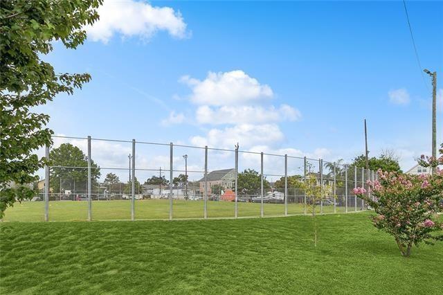 view of community featuring a yard and fence