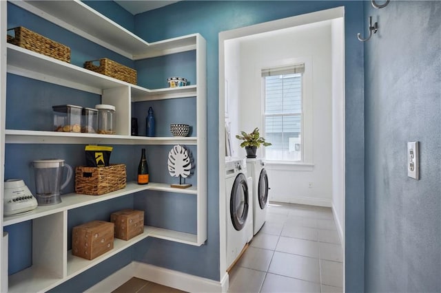 laundry area with laundry area, baseboards, tile patterned floors, and washing machine and clothes dryer