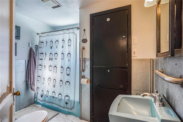 608 Elmira Ave, New Orleans, LA 70114 - bathroom featuring marble finish floor, a sink, visible vents, and a textured ceiling