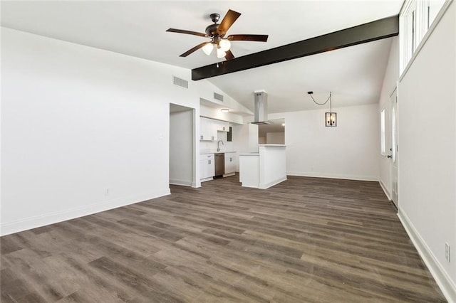 423 Bruce Ave, Terrytown, LA 70056 - unfurnished living room featuring dark wood-type flooring, baseboards, lofted ceiling with beams, a ceiling fan, and a sink