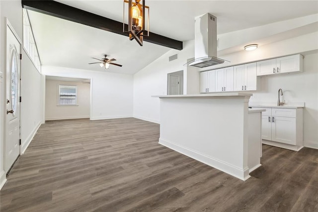 423 Bruce Ave, Terrytown, LA 70056 - kitchen with dark wood finished floors, vaulted ceiling with beams, ceiling fan, light countertops, and island range hood