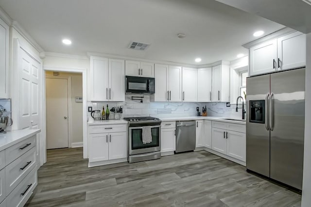 9025 Camille Ct, River Ridge, LA 70123 - kitchen with appliances with stainless steel finishes, white cabinetry, light countertops, and recessed lighting