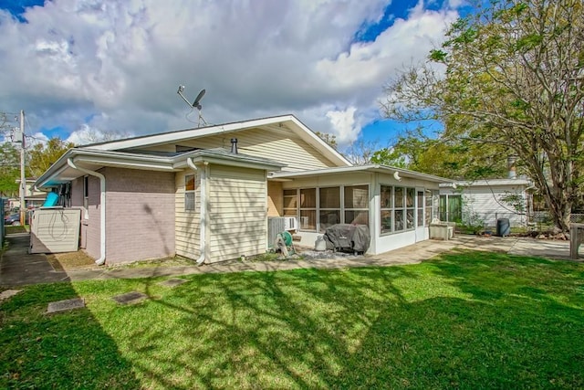 9025 Camille Ct, River Ridge, LA 70123 - back of property featuring a lawn, a sunroom, brick siding, and a patio area