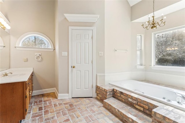 30310 Saint John Dr, Lacombe, LA 70445 - full bath featuring a chandelier, vanity, a jetted tub, baseboards, and brick flooring