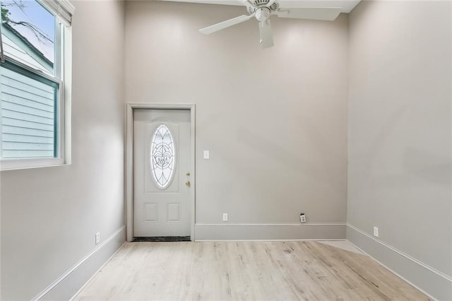 foyer featuring baseboards, light wood-style flooring, and ceiling fan