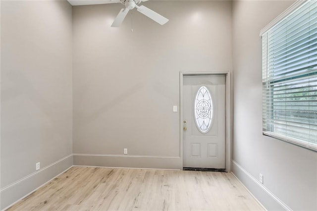 foyer featuring ceiling fan, baseboards, and light wood-type flooring