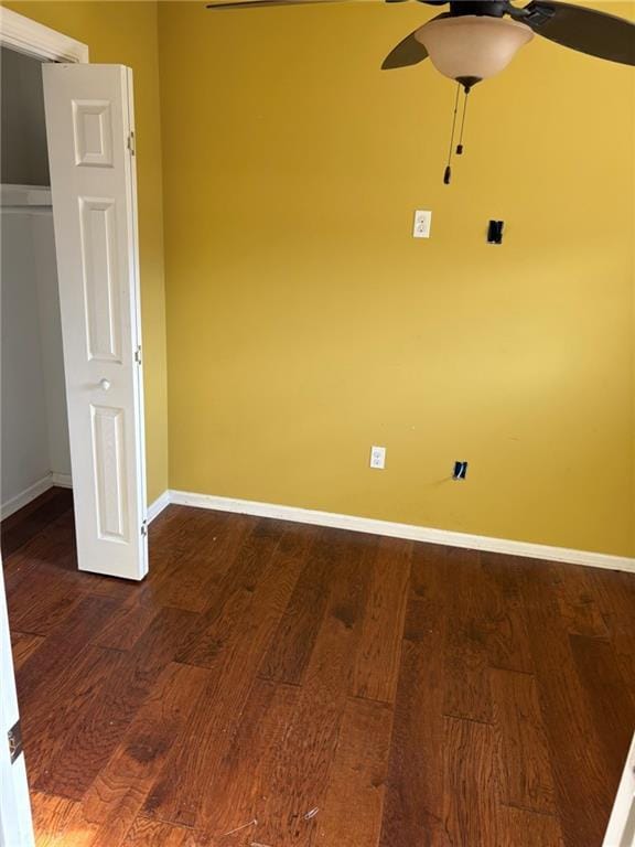 spare room featuring dark wood-style floors, baseboards, and ceiling fan