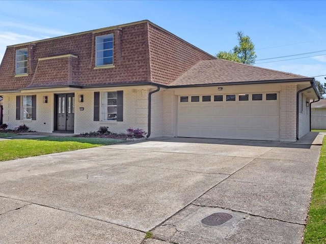 1840 Carol Sue Ave, Terrytown, LA 70056 - view of front facade with driveway, roof with shingles, an attached garage, mansard roof, and brick siding