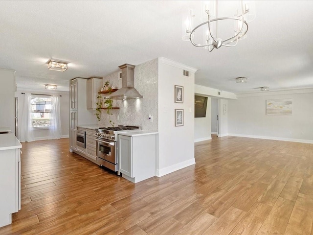 1840 Carol Sue Ave, Terrytown, LA 70056 - kitchen with stainless steel appliances, a notable chandelier, light countertops, and wall chimney range hood