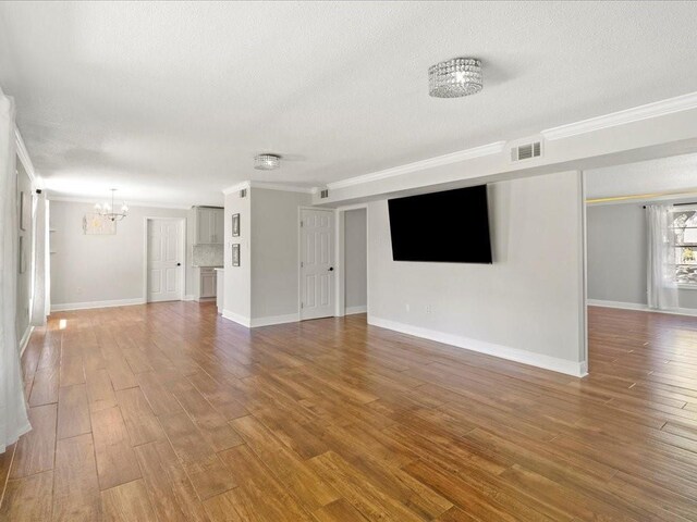 1840 Carol Sue Ave, Terrytown, LA 70056 - unfurnished living room with visible vents, a textured ceiling, an inviting chandelier, and wood finished floors