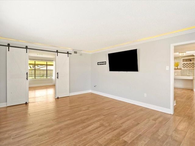 1840 Carol Sue Ave, Terrytown, LA 70056 - empty room featuring light wood finished floors, visible vents, crown molding, and a barn door