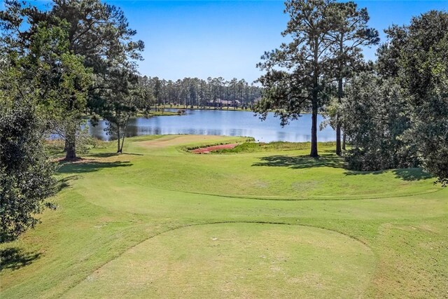 view of home's community featuring a yard, view of golf course, and a water view