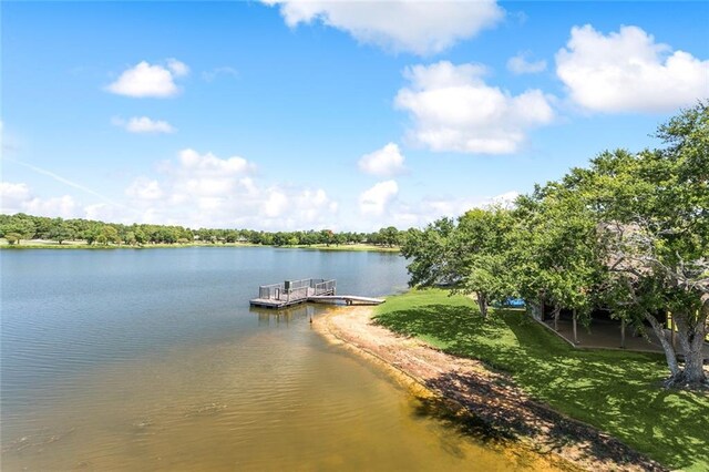 view of dock with a water view and a yard
