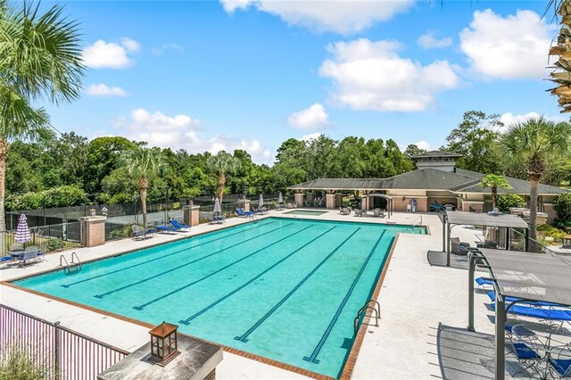 community pool featuring a patio area and fence
