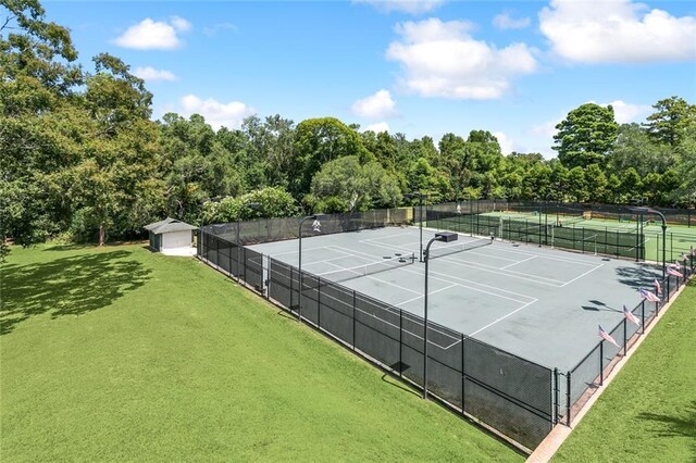 view of sport court with a lawn and fence