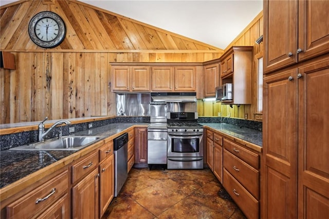 kitchen featuring brown cabinetry, a sink, stainless steel appliances, vaulted ceiling, and under cabinet range hood