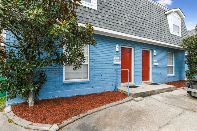 372931 Lilac Ln, Metairie, LA 70001 - view of front of property with mansard roof, a shingled roof, and brick siding