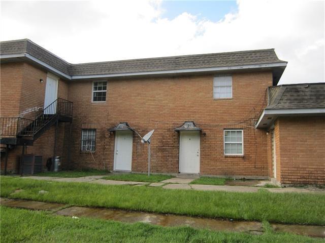 view of front facade featuring brick siding, cooling unit, and a front yard