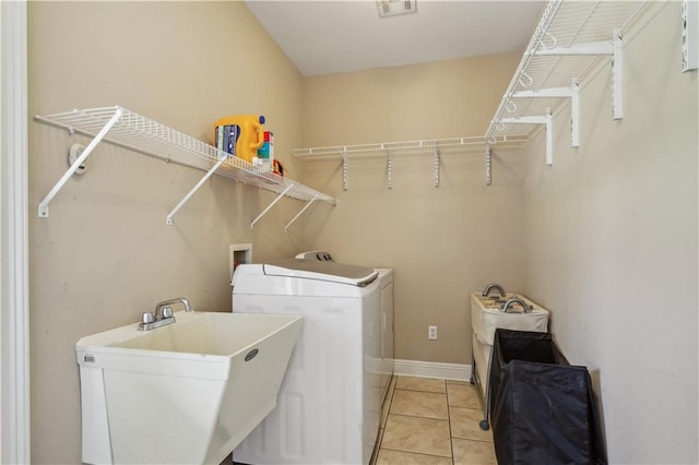 laundry area with visible vents, a sink, light tile patterned floors, laundry area, and washing machine and clothes dryer