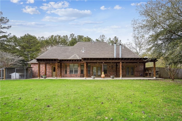 rear view of property with a patio, fence, french doors, a lawn, and brick siding
