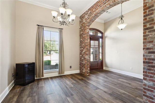 interior space featuring a notable chandelier, crown molding, dark wood-type flooring, and a wealth of natural light