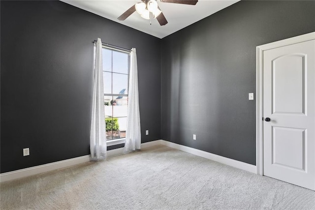 spare room with carpet flooring, baseboards, and ceiling fan