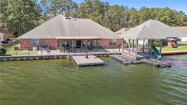 dock area featuring fence and a water view