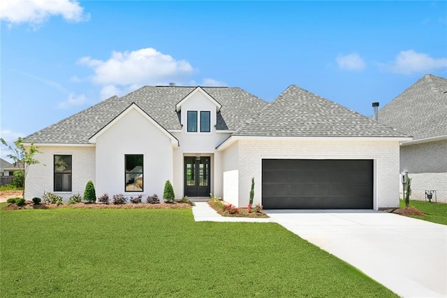 view of front of house featuring an attached garage, roof with shingles, driveway, and a front yard