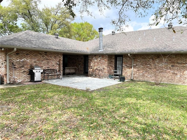 137 Nolan Dr, La Place, LA 70068 - back of house with brick siding, a patio, roof with shingles, and a lawn