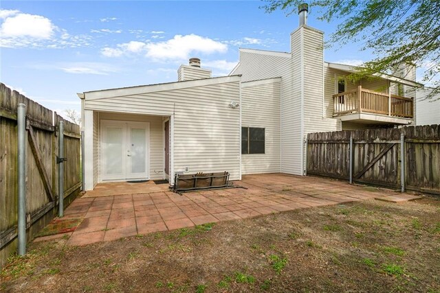 302 Bogie Dr Unit 25D, Slidell, LA 70460 - rear view of property featuring a chimney, a patio area, a fenced backyard, and a gate