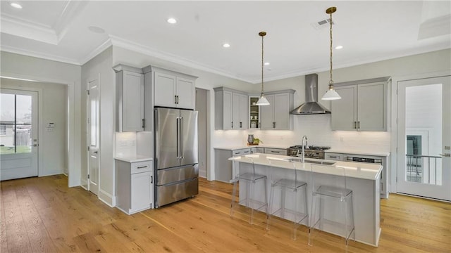 8520 Creole Dr, Chalmette, LA 70043 - kitchen with gray cabinetry, light wood-type flooring, light countertops, high quality fridge, and wall chimney exhaust hood
