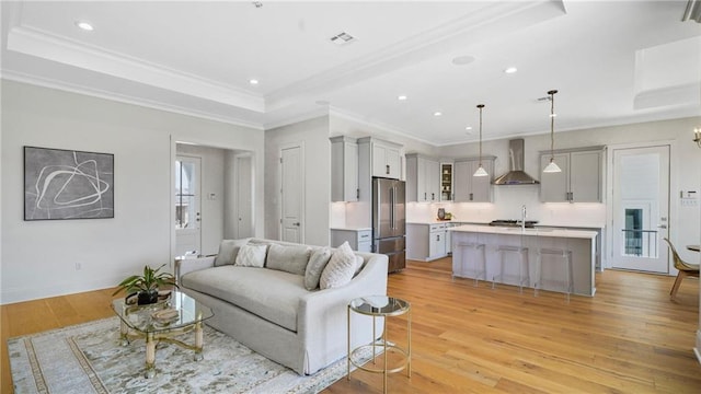 8520 Creole Dr, Chalmette, LA 70043 - living room with a raised ceiling, light wood-style flooring, crown molding, and visible vents