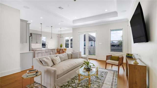 8520 Creole Dr, Chalmette, LA 70043 - living room featuring a raised ceiling, baseboards, visible vents, and light wood finished floors