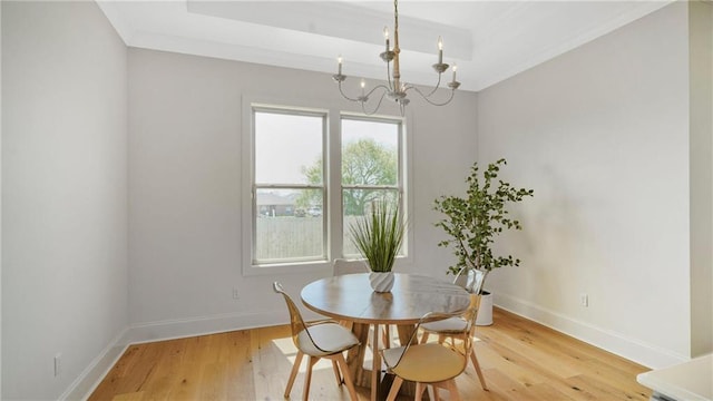 8520 Creole Dr, Chalmette, LA 70043 - dining room featuring baseboards, a raised ceiling, an inviting chandelier, and light wood finished floors