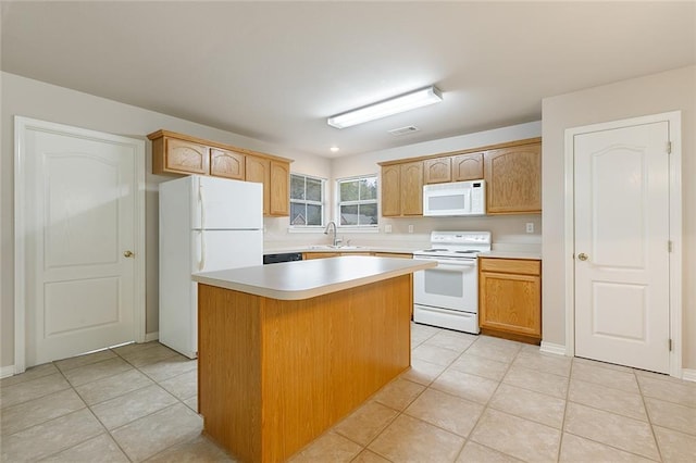 kitchen with light countertops, a sink, a kitchen island, light tile patterned floors, and white appliances