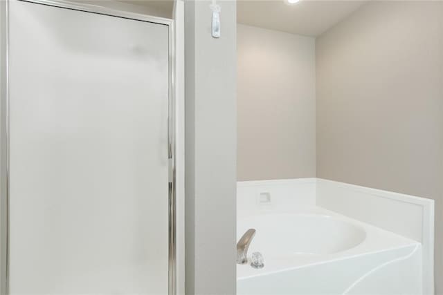 full bathroom featuring a garden tub and a stall shower