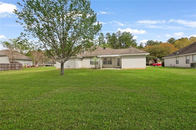 rear view of property featuring central AC and a yard
