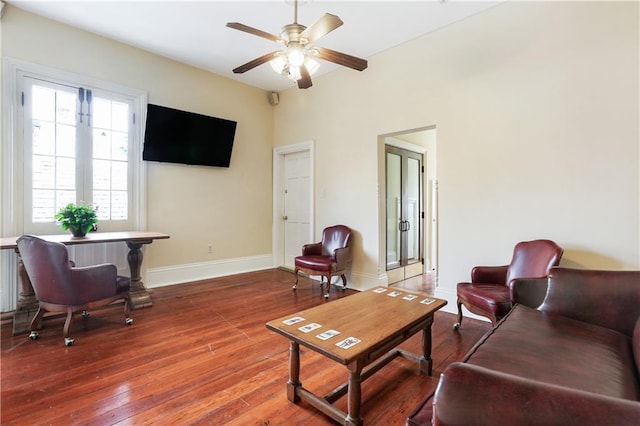 living area with baseboards, ceiling fan, and hardwood / wood-style flooring