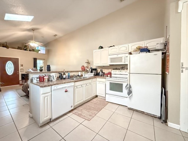 5930 Louisville St, New Orleans, LA 70124 - kitchen with a sink, white appliances, a peninsula, a skylight, and light tile patterned floors