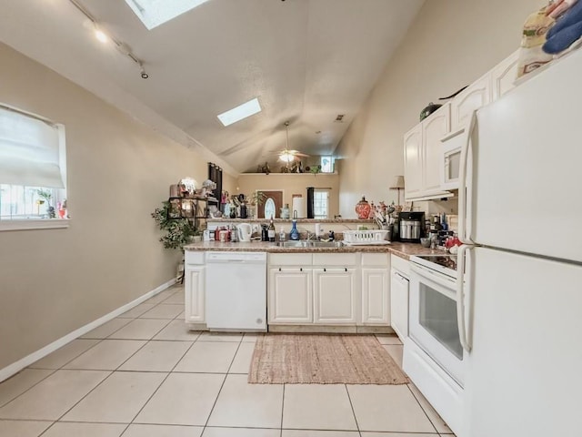 5930 Louisville St, New Orleans, LA 70124 - kitchen with white appliances, a peninsula, vaulted ceiling with skylight, light tile patterned flooring, and white cabinetry