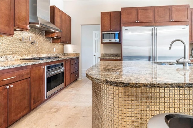 5878 General Haig St, New Orleans, LA 70124 - kitchen featuring stainless steel appliances, wall chimney exhaust hood, tasteful backsplash, light stone countertops, and light tile patterned flooring