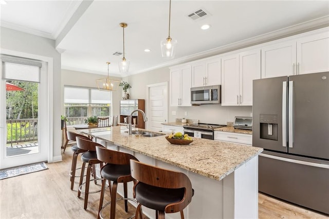 kitchen featuring a sink, light wood-style floors, visible vents, white cabinets, and appliances with stainless steel finishes