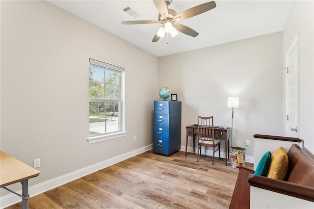 living area featuring a ceiling fan, visible vents, wood finished floors, and baseboards