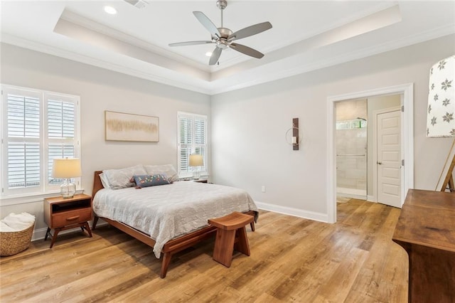bedroom with a raised ceiling, light wood-type flooring, crown molding, and baseboards