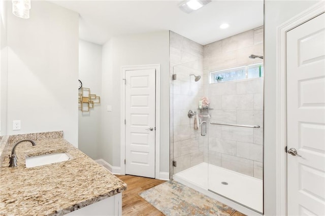 full bathroom featuring recessed lighting, wood finished floors, a shower stall, and vanity