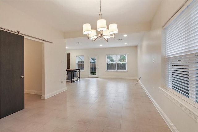 empty room with a barn door, recessed lighting, baseboards, and a chandelier