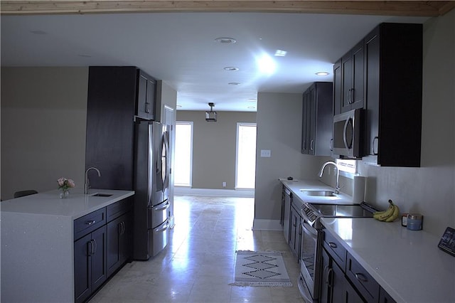 4043 S Pin Oak Ave, New Orleans, LA 70131 - kitchen featuring appliances with stainless steel finishes, light countertops, baseboards, and a sink