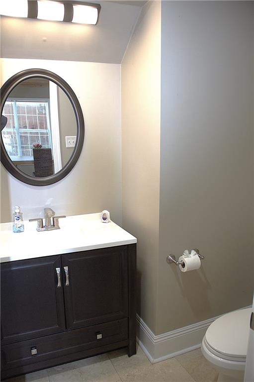 4043 S Pin Oak Ave, New Orleans, LA 70131 - half bath with vanity, tile patterned floors, toilet, and baseboards