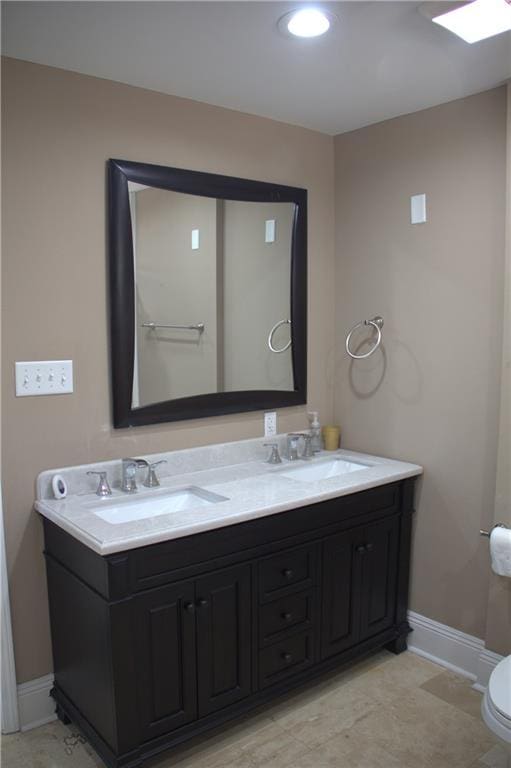 4043 S Pin Oak Ave, New Orleans, LA 70131 - bathroom featuring double vanity, toilet, baseboards, and a sink