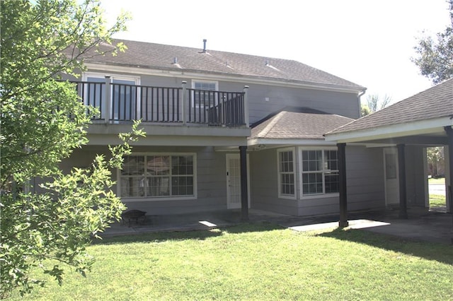 4043 S Pin Oak Ave, New Orleans, LA 70131 - back of house featuring a lawn, a balcony, a shingled roof, an attached carport, and a patio area